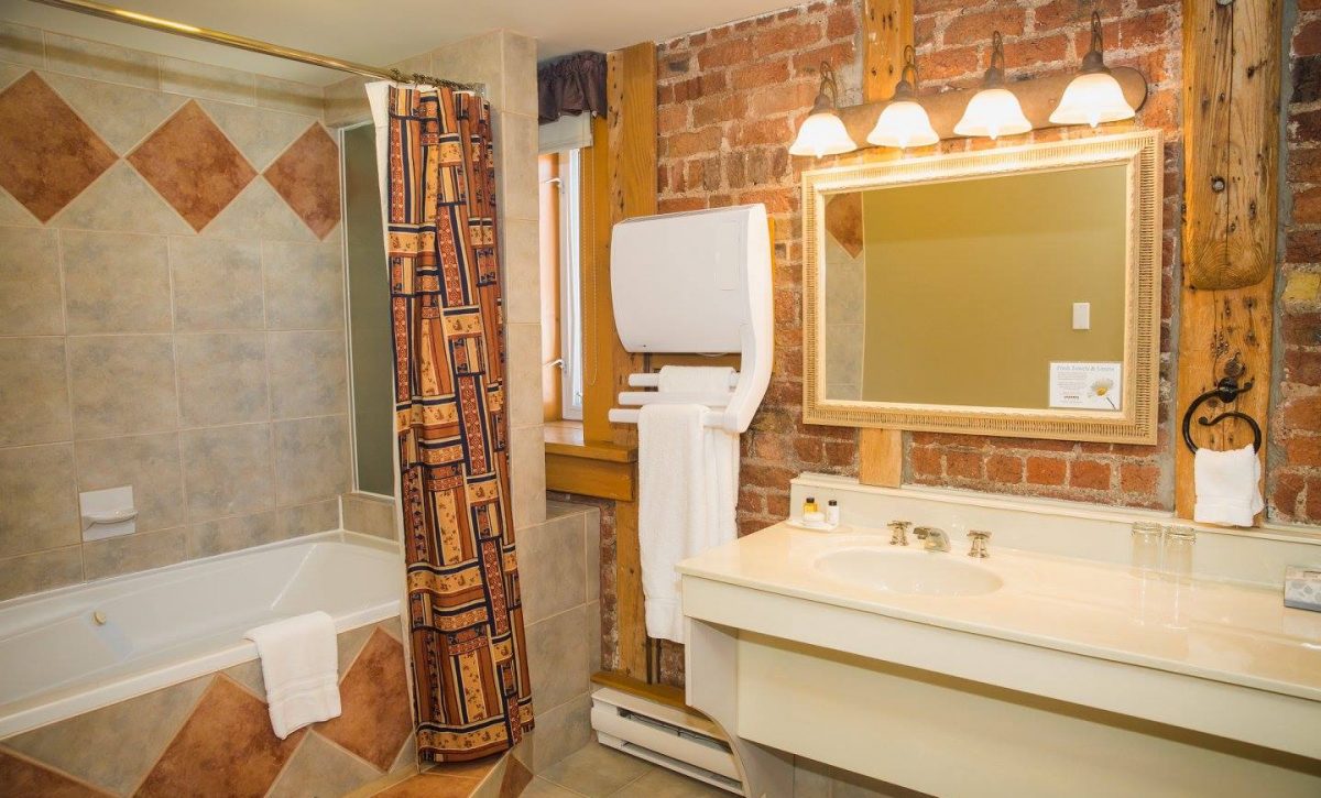 Queen Bathroom with towel warmer and exposed brick wall.