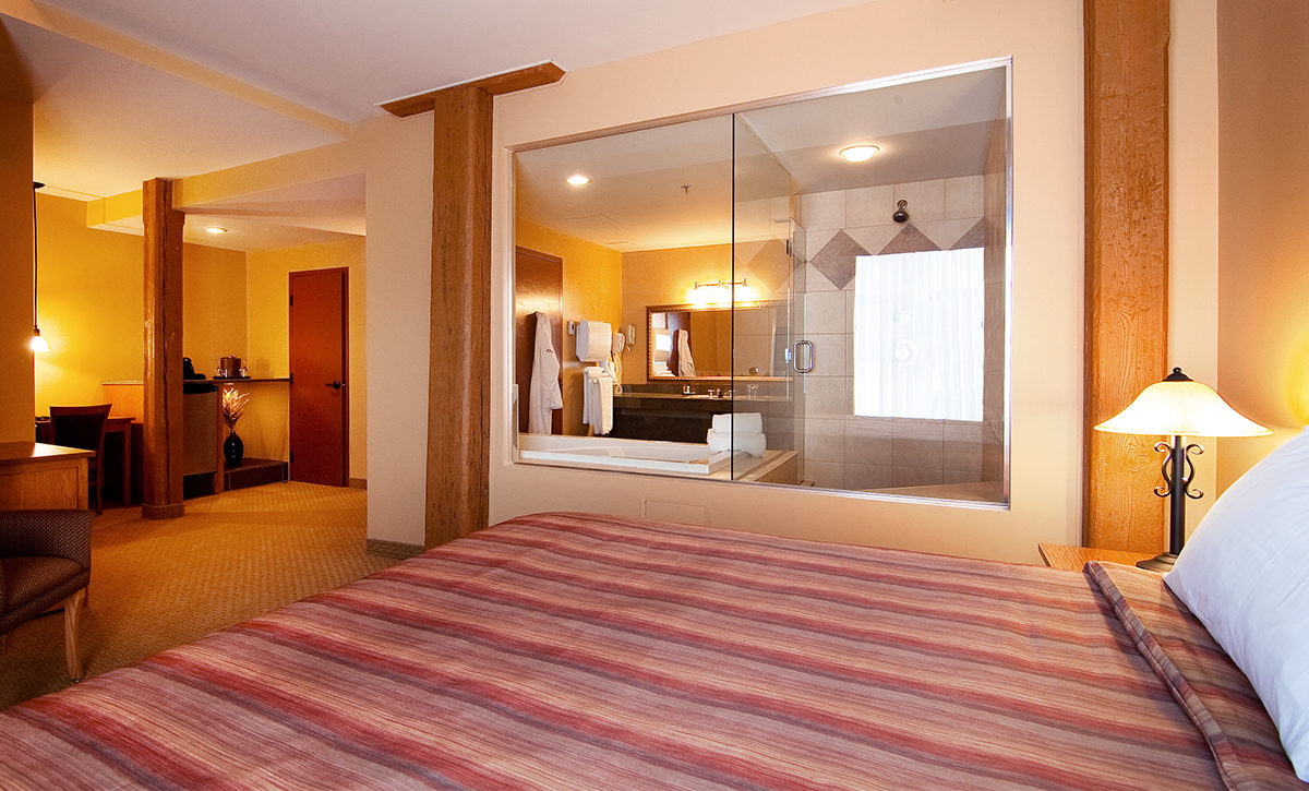 Signature King Room with one-person jetted tub, spa shower, and glass walls.