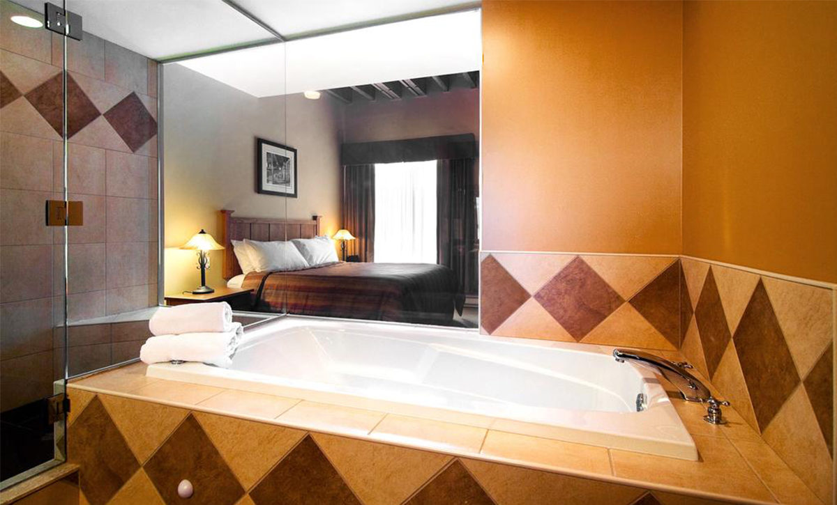 Signature King Room with one-person jetted tub, spa shower, and glass walls.